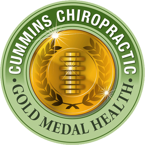 A gold medal logo with a stylized spine in the center, surrounded by laurel leaves. The outer green ring reads Cummins Chiropractic at the top and Gold Medal Health at the bottom.