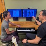 chiropractic care for chronic pain | malew doctor examining xrays with female patient in front of computer screen